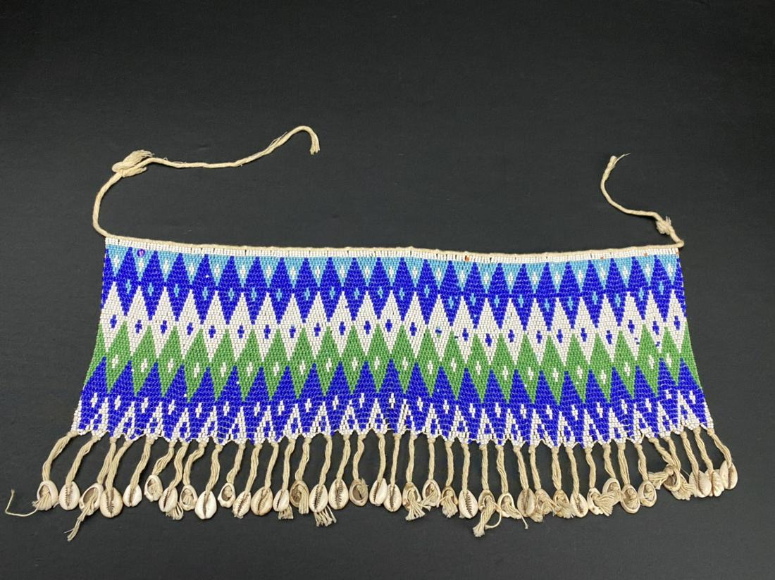 A Vintage African Modesty Belt: A beaded Cache Sexe, enhanced with cowrie shells. Traditionally worn by the Kirdi women of Cameroon, such belts were outlawed in recent times in favor of Western dress.