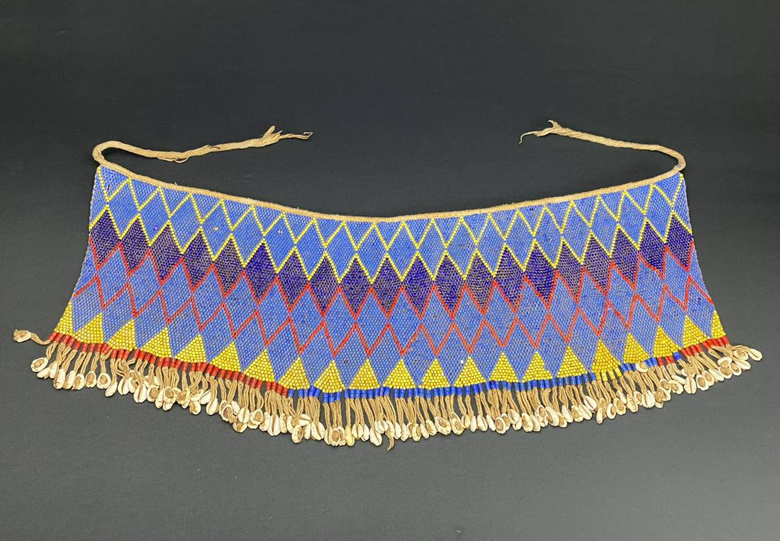 A Vintage African Modesty Belt: A beaded Cache Sexe, enhanced with Cowrie shells. Traditionally worn by the Kirdi women of Cameroon, such belts were outlawed in recent times in favor of Western dress.