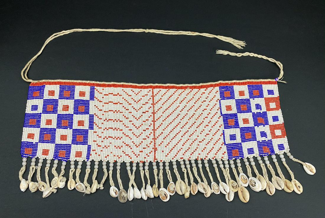 A Vintage African Modesty Belt: A beaded Cache Sexe, enhanced with Cowrie shells. Traditionally worn by the Kirdi women of Cameroon, such belts were outlawed in recent times in favor of Western dress.