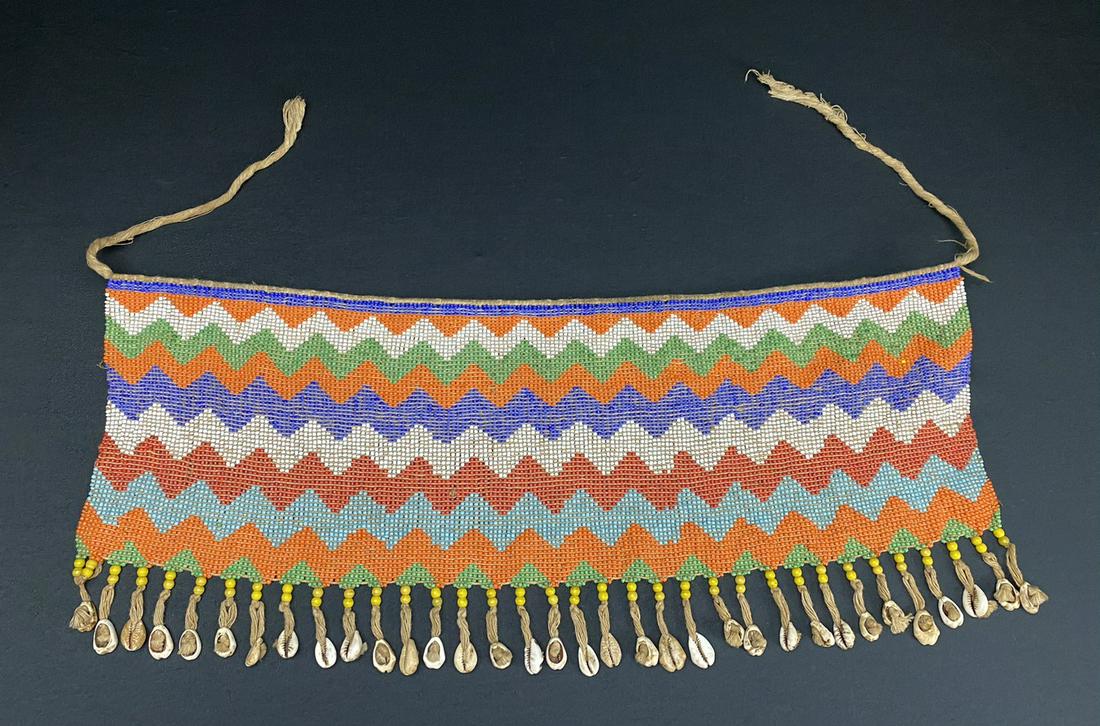 A Vintage African Modesty Belt: A beaded Cache Sexe, enhanced with cowrie shells.Traditionally worn by the Kirdi women of Cameroon, such belts were outlawed in recent times in favor of Western dress.