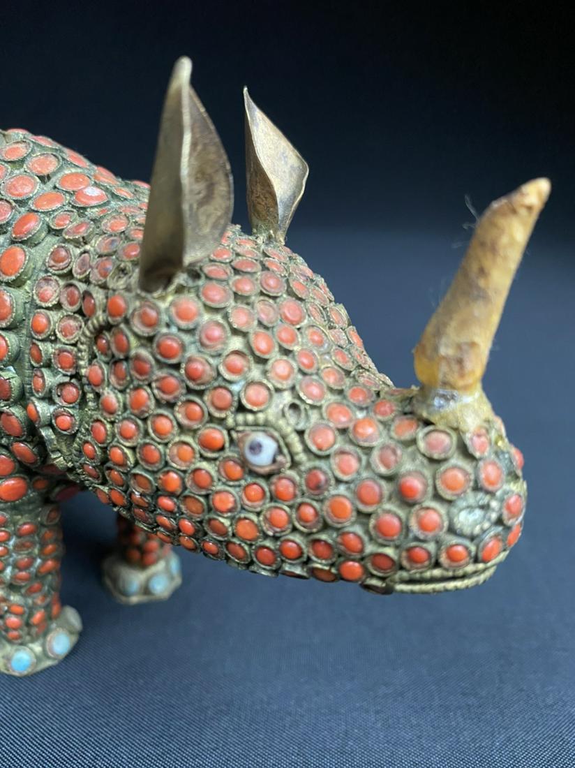 Vintage Asian Red Coral Rhinoceros Figure: Vintage Asian Rhinoceros figure with red coral and turquois inlay. Brass feet, bone horn