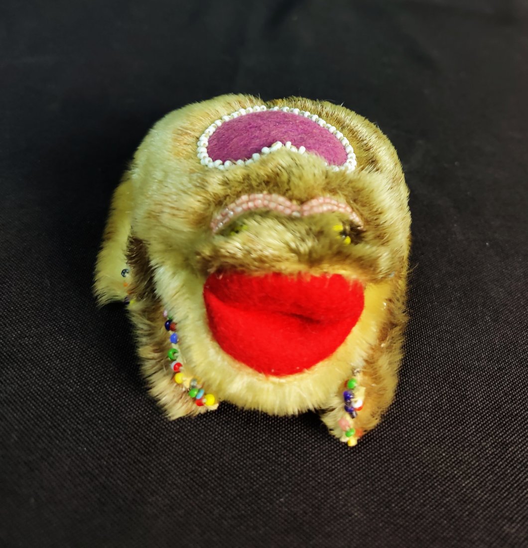 Inuit Pin Cushion with real fur: This genuine Inuit Pin Cushion is made with real fur and and has rainbow bead work along its feet. It has bright yellow beaded eyes and a pair red felt lips. On the back of it there is a purple felt h