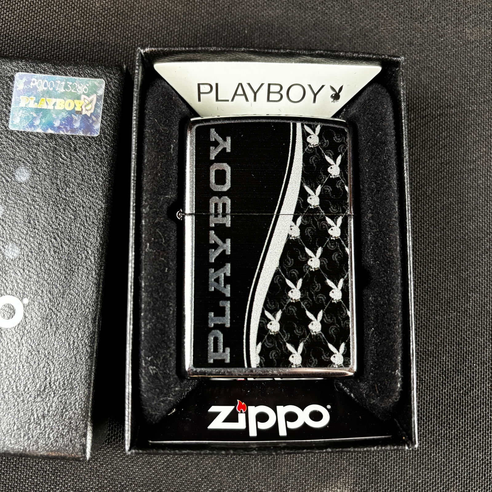 Playboy Zippo Lighter: Playboy Zippo lighter, in original box, with original lighter seal on back. Never been used. Condition is excellent. E, 13 stamped model markings at bottom of lighter. Box measures 3 15/16 tall by 2 5