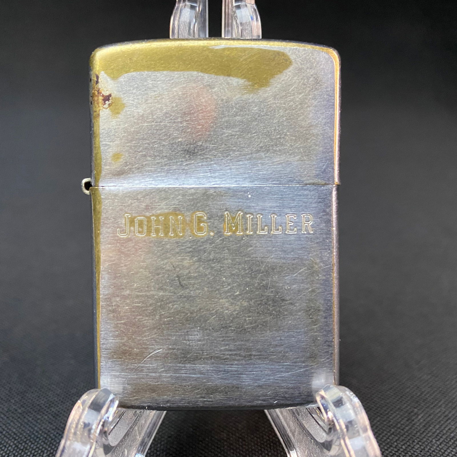 Brushed Aluminum Zippo Lighter with Stamped Name on Front: Brushed Aluminum Zippo Lighter with Stamped Name on Front, John G. Miller. Used. Condition is Poor. Pat. 2517191 stamped model markings at bottom of lighter.