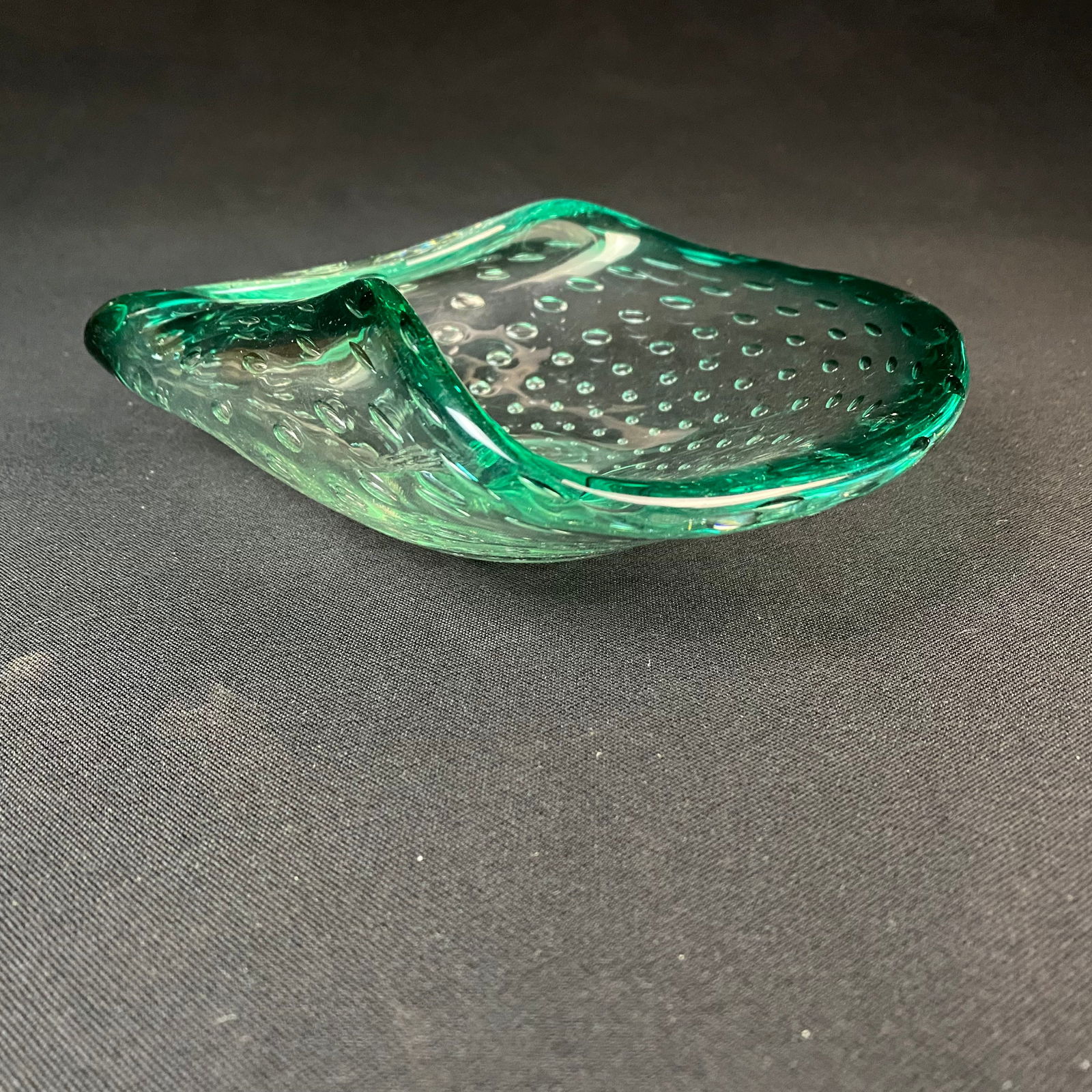 Mid Century Green Murano Bullicante Glass Tray Shaped in a Curled Leaf-like Design: Mid Century Green Murano Bullicante Glass Tray Shaped in a Curled Leaf-like Design. Condition is excellent with minor surface wear and grime. It measures 7 3/4 long by 6 3/4 wide by 2 1/2 tall.