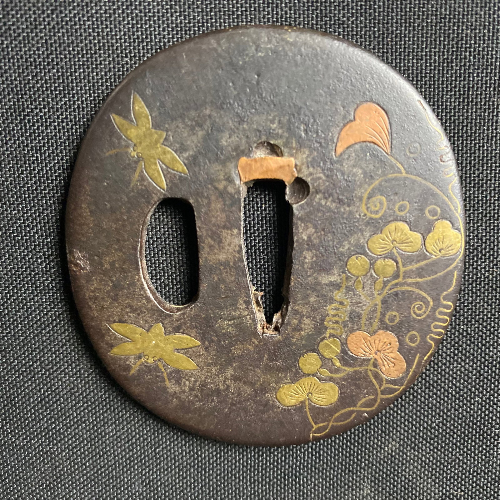 19th Century Iron and Mixed Metal Tsuba, Japan Edo Period (1603-1868): 19th Century Iron and Mixed Metal Tsuba, Japan Edo Period (1603-1868). It has Scrolled gold and copper inlayed details of cherry blossoms, flying insects, and artistic scrolling and linework. Conditio