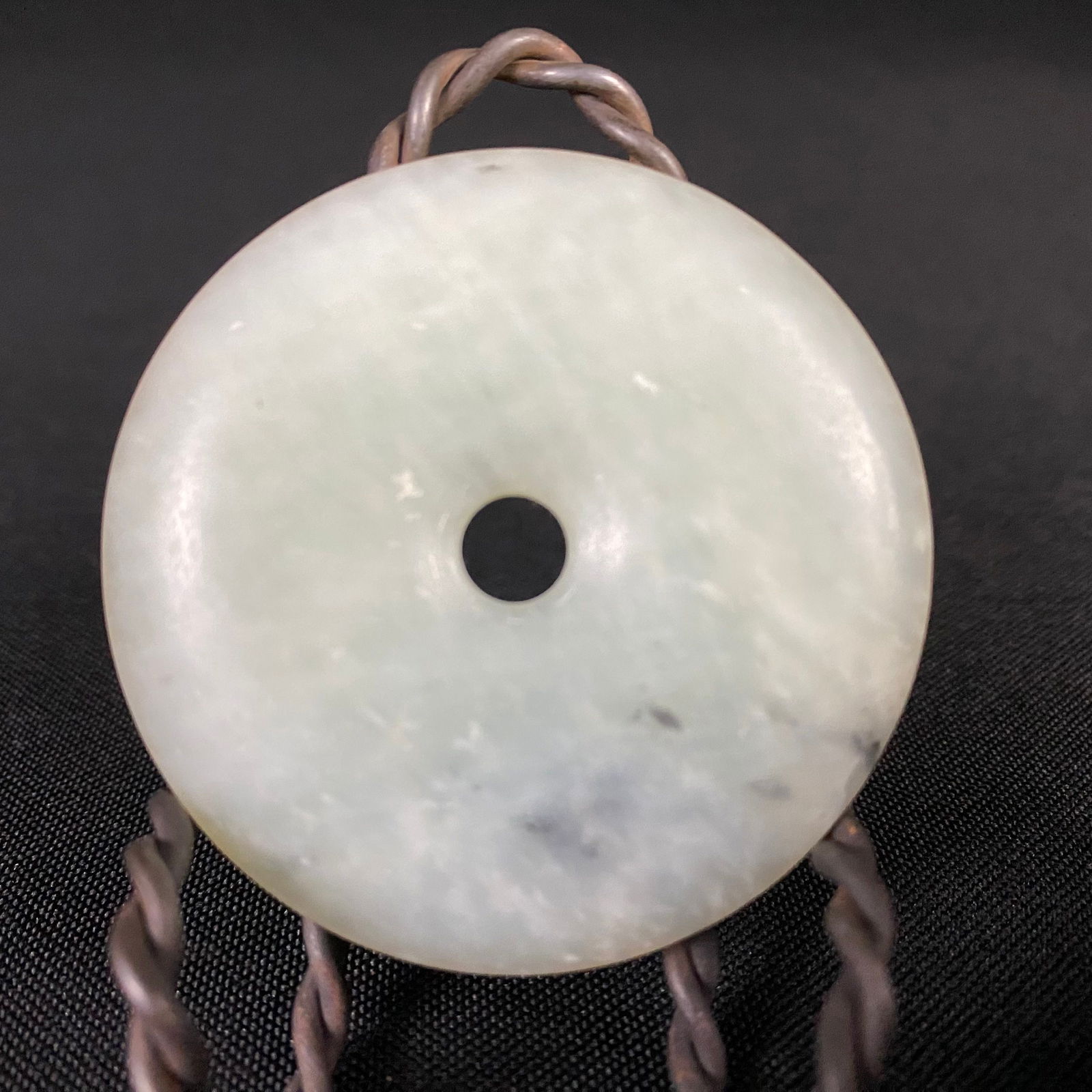 Chinese Hard Stone Bi: Chinese Hard Stone Bi possibly Jade. Condition is excellent with minor surface wear and scratches. It has a hole in the center to adorn it to a necklace or lanyard. It measures 2 1/4 in diameter by 5/
