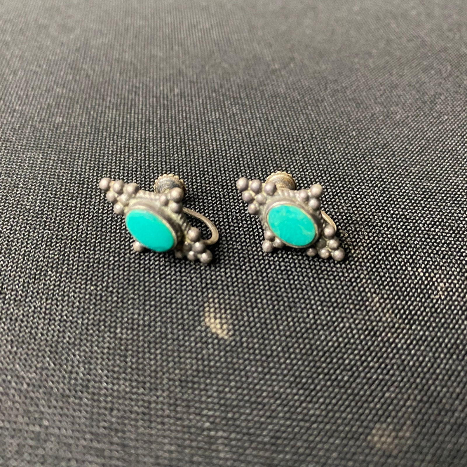 Sterling Silver and Turquoise Screw Back Earrings: Sterling Silver and Turquoise Screw Back Earrings. They are in Excellent condition with minor surface wear and grime. They have an oval Turquoise stone in the center with groups of 3 and 6 silver bead
