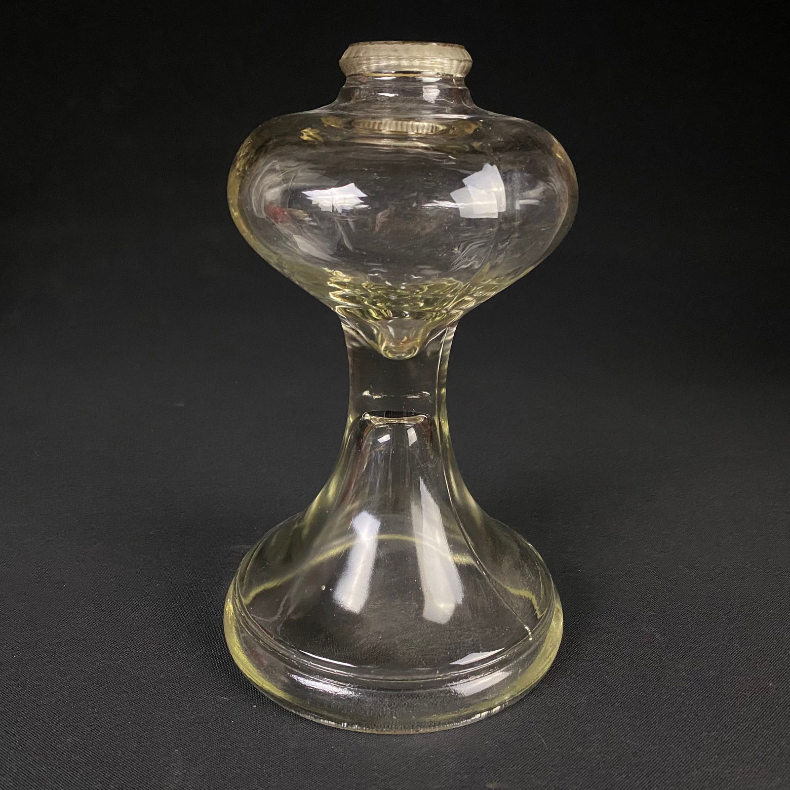 Hourglass Shaped Oil Lamp Base: Hourglass Shaped Oil Lamp Base. It is in great condition with no breaks, cracks, or chips, and minor surface scratches. It has minimal surface grime, and the brass knock fitting has a slight patina.