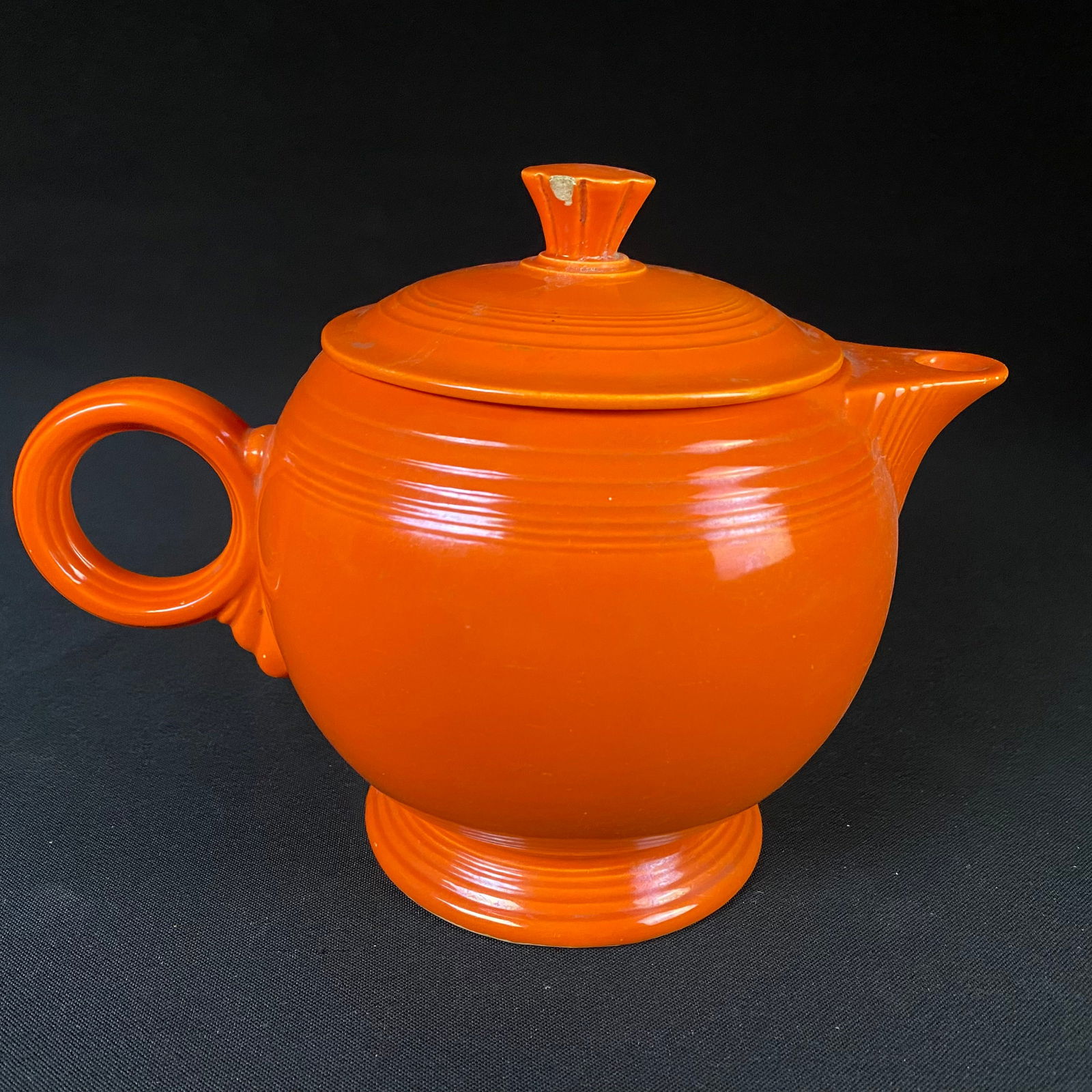Vintage Homer Laughlin Fiesta Orange Pitcher with Lid: Vintage Homer Laughlin Fiesta Orange Pitcher with Lid. Condition is good with a couple chips to the lid and pitcher. One chip out is at the top of the lid's handle, and the other break is on the insid