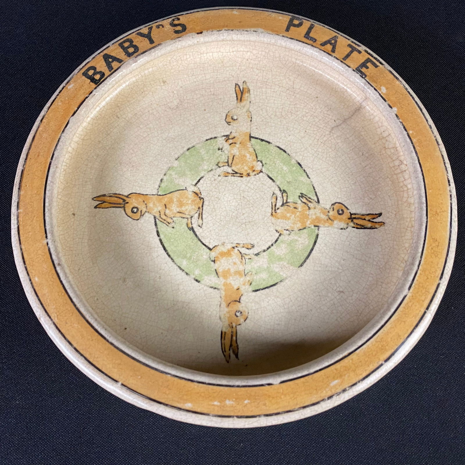 Antique Roseville Pottery Creamware Baby Plate: Antique Roseville Pottery Creamware Baby Plate. Condition is good with some surface grime, and the finish wearing through to the white base in many spots. This plate has four rabbits standing around t