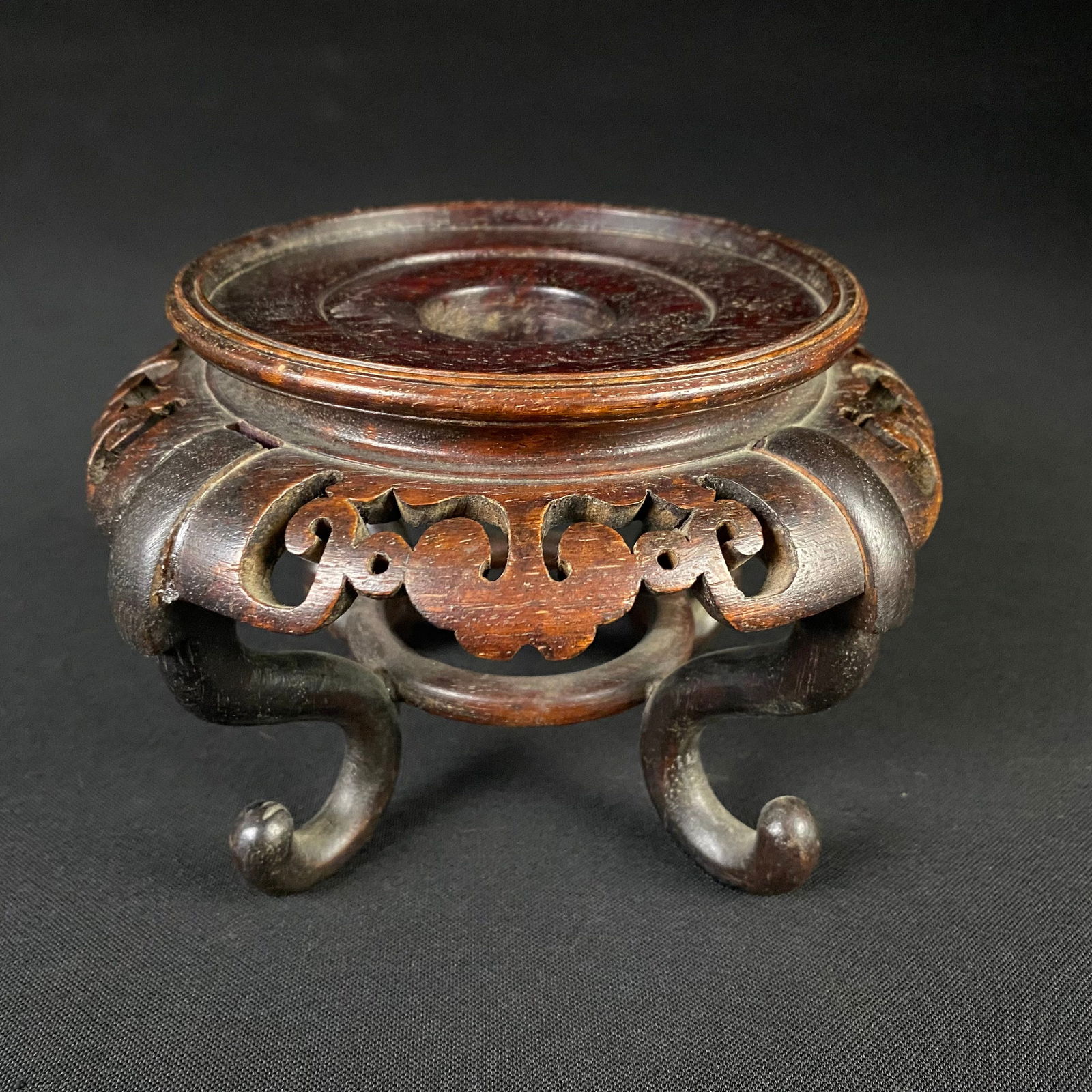 Chinese Hardwood Bonsai or Vase Display Stand: Chinese Hardwood Bonsai or Vase Display Stand. It is in great condition with some surface wear and mild surface grime. It has four curved legs with curled feet, joined by a wooden ring in the center.