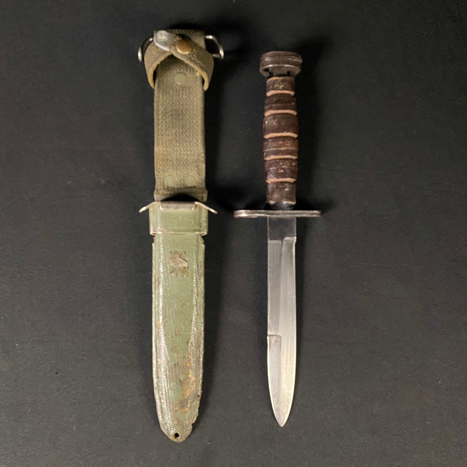 M4 Bayonet in a US M8 Scabbard: M4 Bayonet in a US M8 Scabbard. It is in good used condition with some minor damage to the handle. One side of the handle near the pommel end of the knife is broken out (see photos). The scabbard has