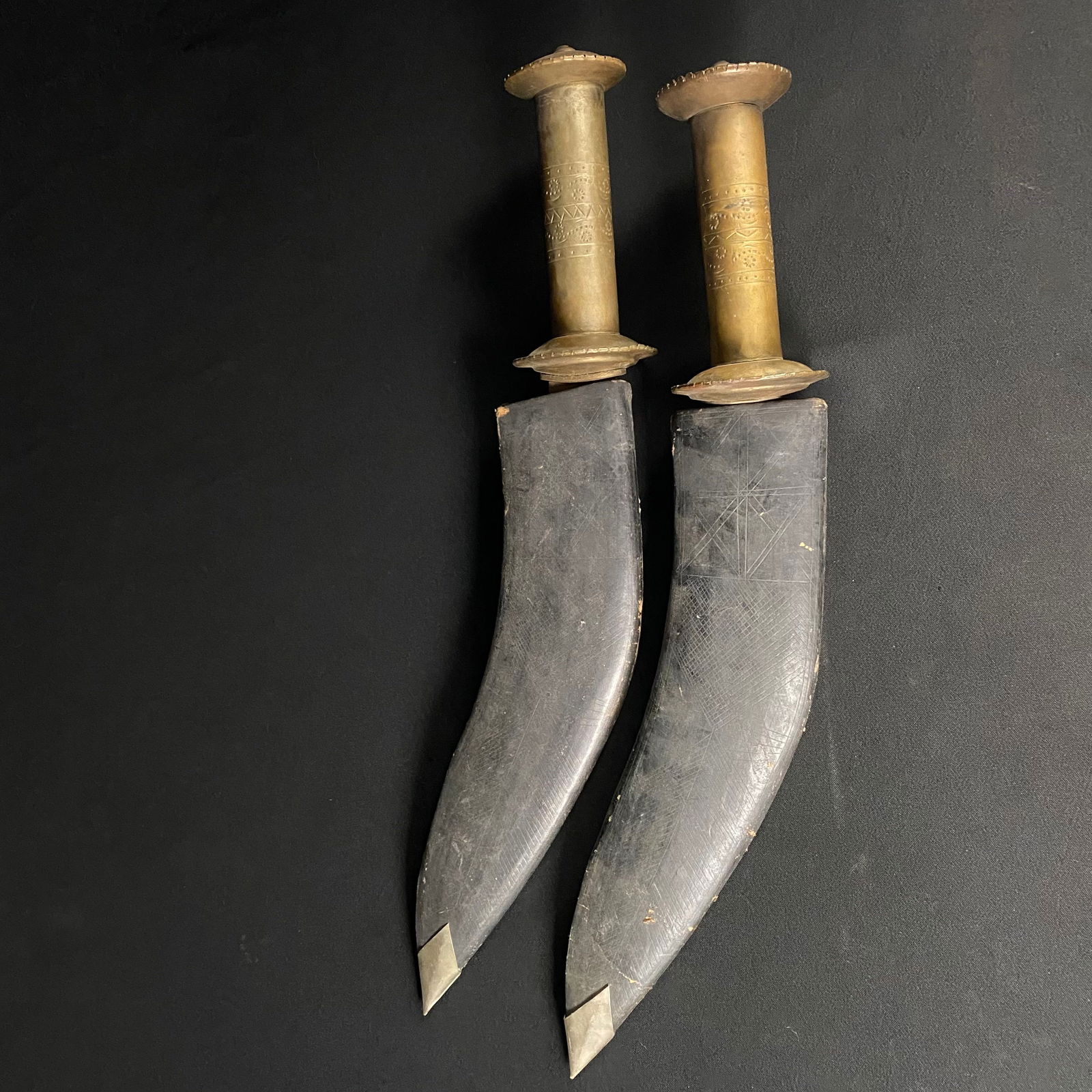 Antique Pair of Middle Eastern Kukuri: Antique Pair of Middle Eastern Kukuri. They are in good condition with minor wear and surface grime, and some damage to the scabbards. One is completely missing the leather belt strap, and the other h