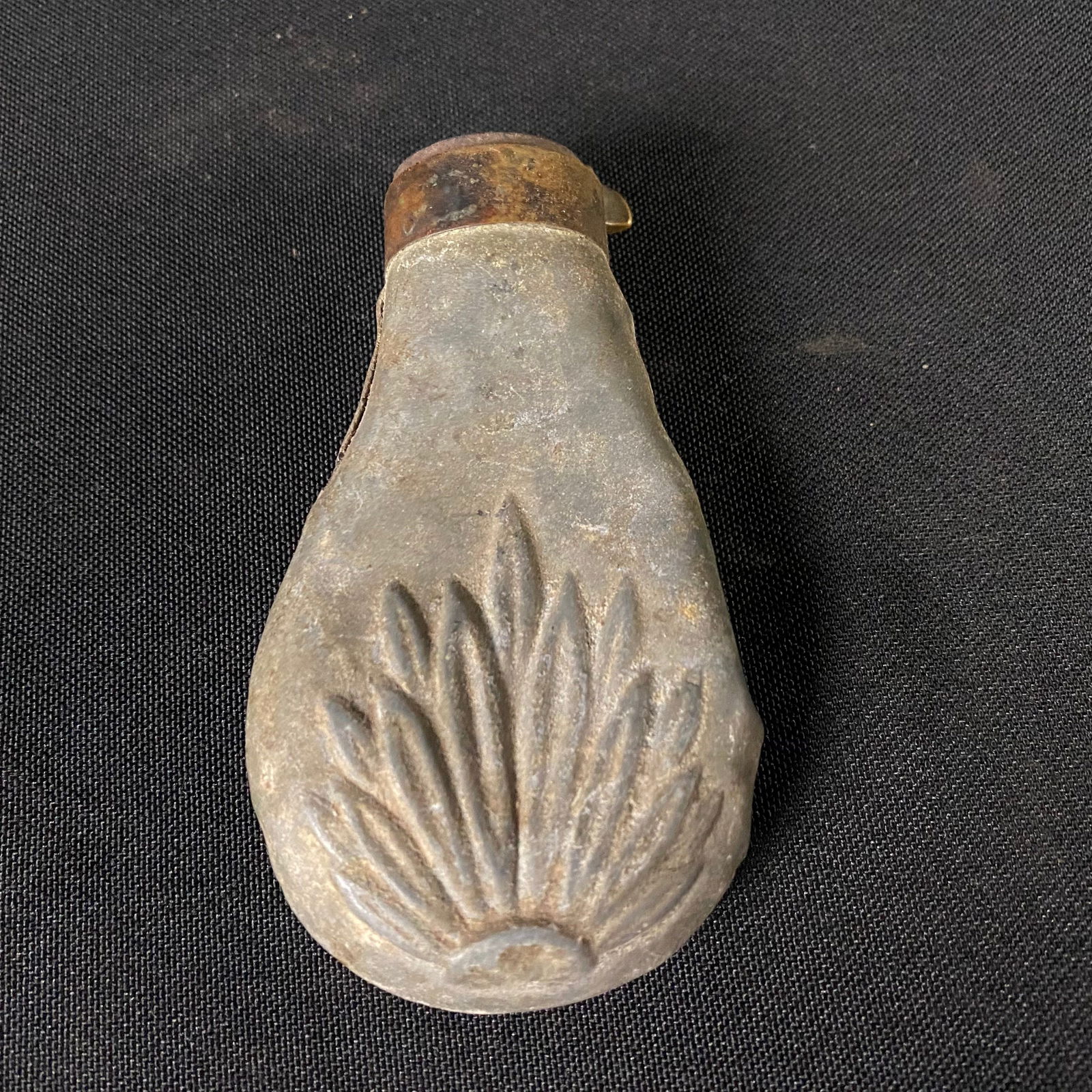 Antique Floral Design Pewter Powder Flask from The Civil War: Antique Floral Design Pewter Powder Flask from The Civil War. It is in fair condition, with wear to be expected with age and use. It appears to have been crushed by something heavy, and has some major