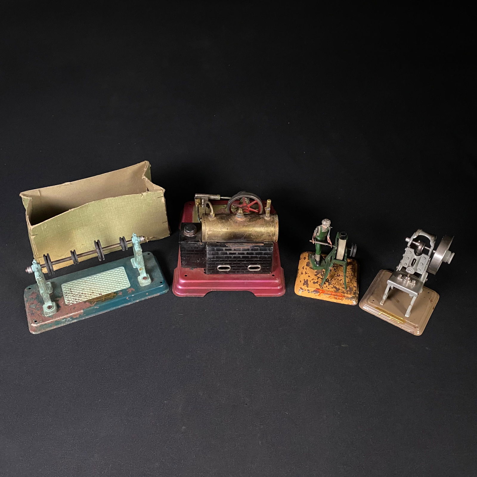 Vintage Set of 4 Mid Century German Made Fleischmann Steam Engine Toys: Vintage Set of 4 Mid Century German Made Fleischmann Steam Engine Toys. Number 1: Steam Engine: It measures 5 tall by 7 1/8 wide by 6 deep, and weighs 13.3 oz. It has a red base with brass water tank