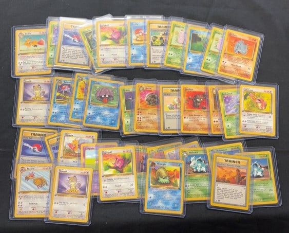 (37) VINTAGE 1ST EDITION POKEMON CARDS: In penny sleeves and top loaders. Each case measures 3" x 4".