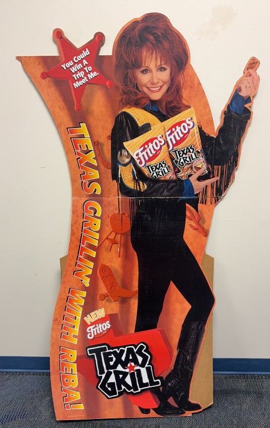 REBA MCENTIRE FRITOS TEXAS GRILL CARDBOARD SIGN: Some wear and bends. Measures 37" in width and stands 67" in height.