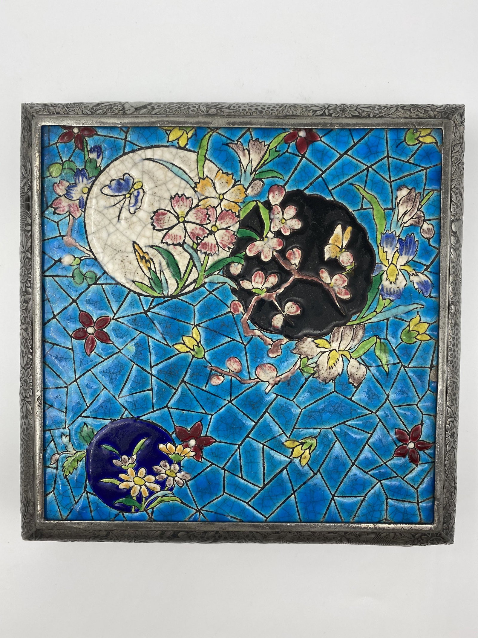 Decorative Longwy Tile Set in Silver Trivet: Decorative on its own, this Longwy tile was set in an elaborate silver mount to form a plateau or serving trivet. The circular motifs in white, black, and navy blue on a turquoise blue background prov