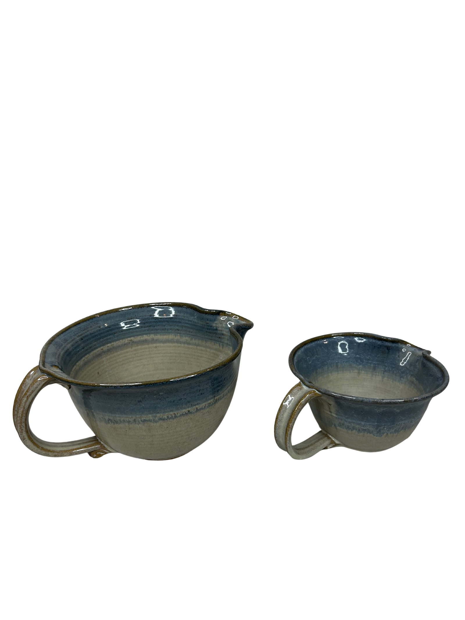 Handcrafted Blue Gradient Ceramic Pitcher Set with Shell Motif: This is a charming set of two hand-thrown ceramic pitchers, each exhibiting a beautiful gradient from light beige to a soothing blue hue. The larger pitcher stands out with its substantial width of