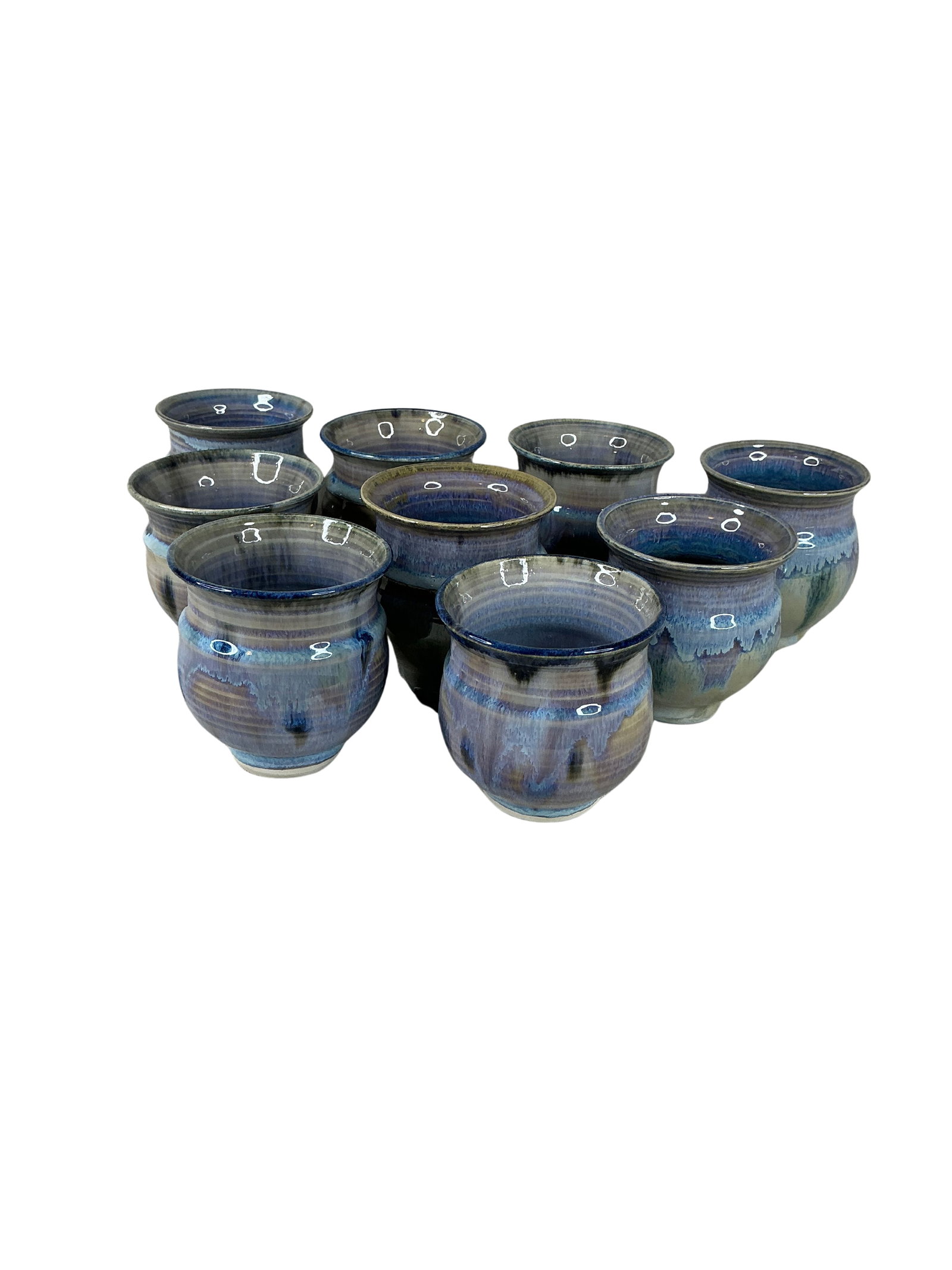 Set of 9 Handmade Artisan Ceramic Mugs in Blue Glaze: This collection features nine exquisite studio crafted handmade ceramic mugs. Each mug showcases a harmonious blend of blue and earthy tones, applied in a glossy glaze that highlights the unique