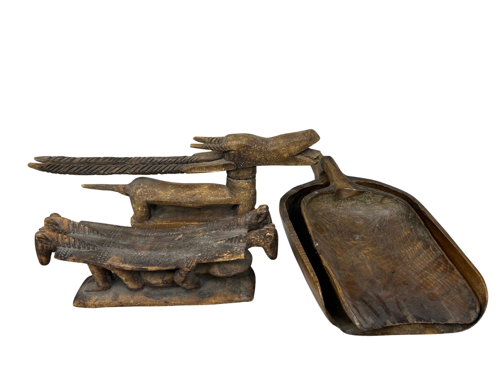 Set of 4 Hand-Carved Ethnic Wooden Sculptures: This lot features four intricately hand-carved wooden sculptures, showcasing a distinct artisanal craftsmanship. The objects display a rustic charm, with earthy tones and a weathered patina that contr