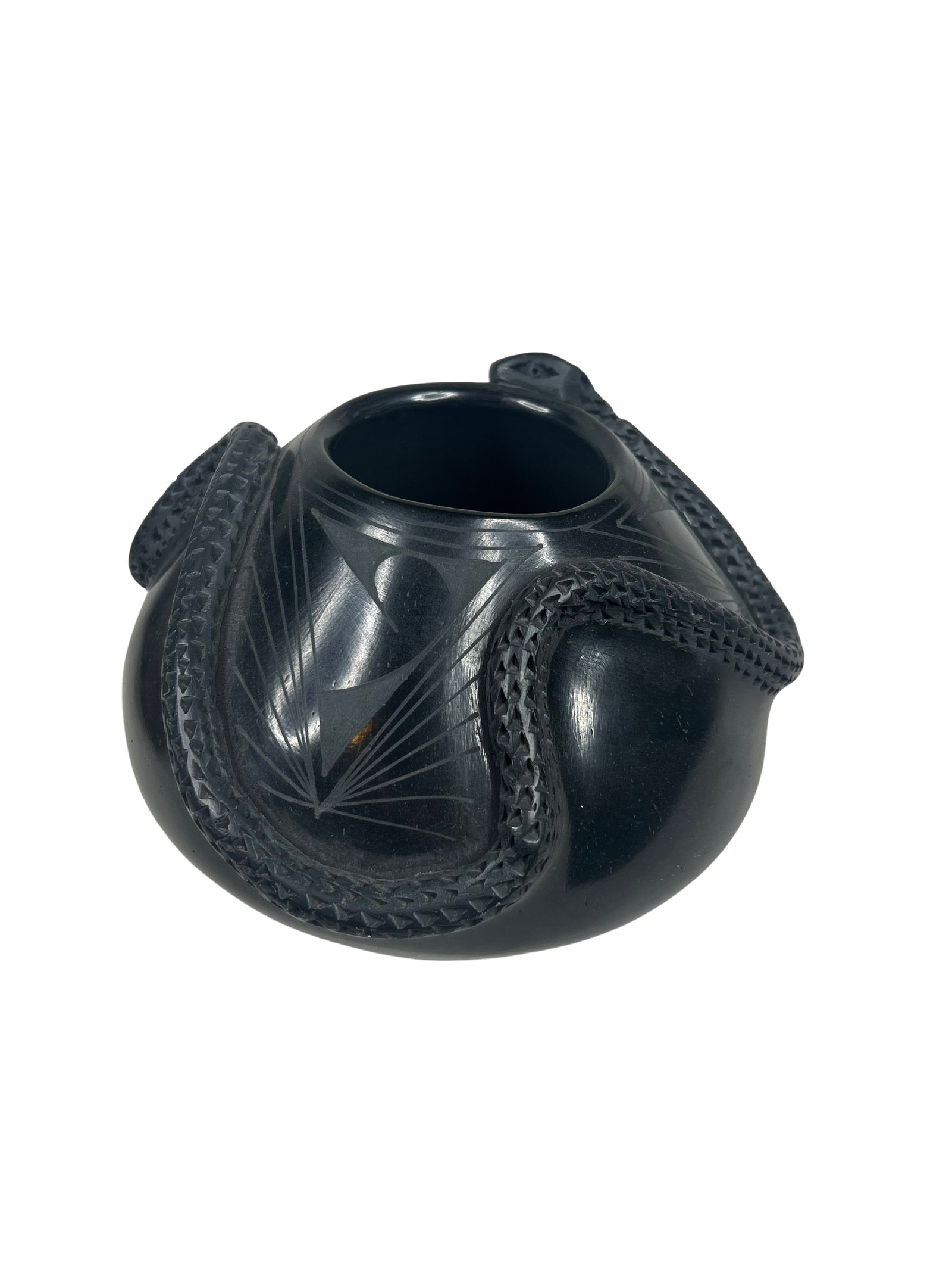 Olivia Dominguez Etched Blackware Pot with Serpent Motif: This exquisite piece of blackware pottery is expertly crafted by Olivia Dominguez, featuring a beautifully etched design complemented by raised, textured embellishments. The pottery displays a strikin