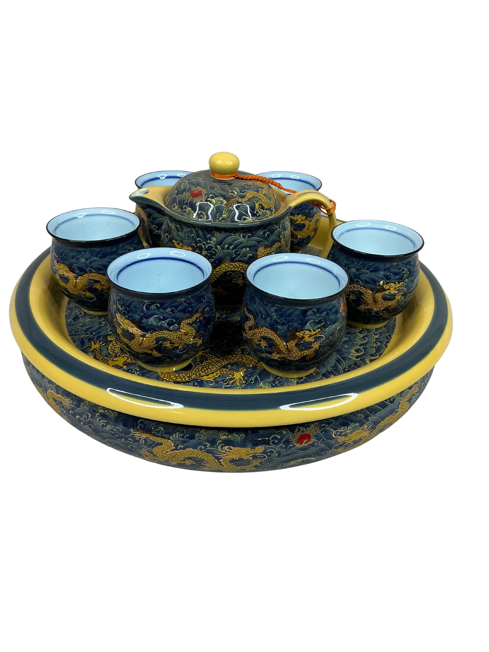 Exquisite Chinese Dragon Porcelain Tea Set: This exquisite Chinese tea set presents a rich display of traditional craftsmanship with modern touches. The set features a deep blue base color adorned with intricate golden dragon designs, providing