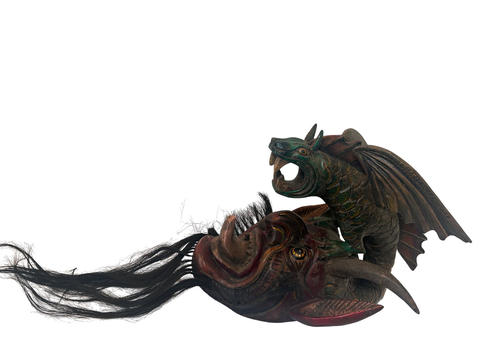 Handcrafted Ceremonial Dragon Mask with Hair Accents: This striking mask appears to be a handcrafted piece likely intended for ceremonial or decorative use. It features a vivid array of colors, prominently showcasing deep reds, greens, and golds. The des