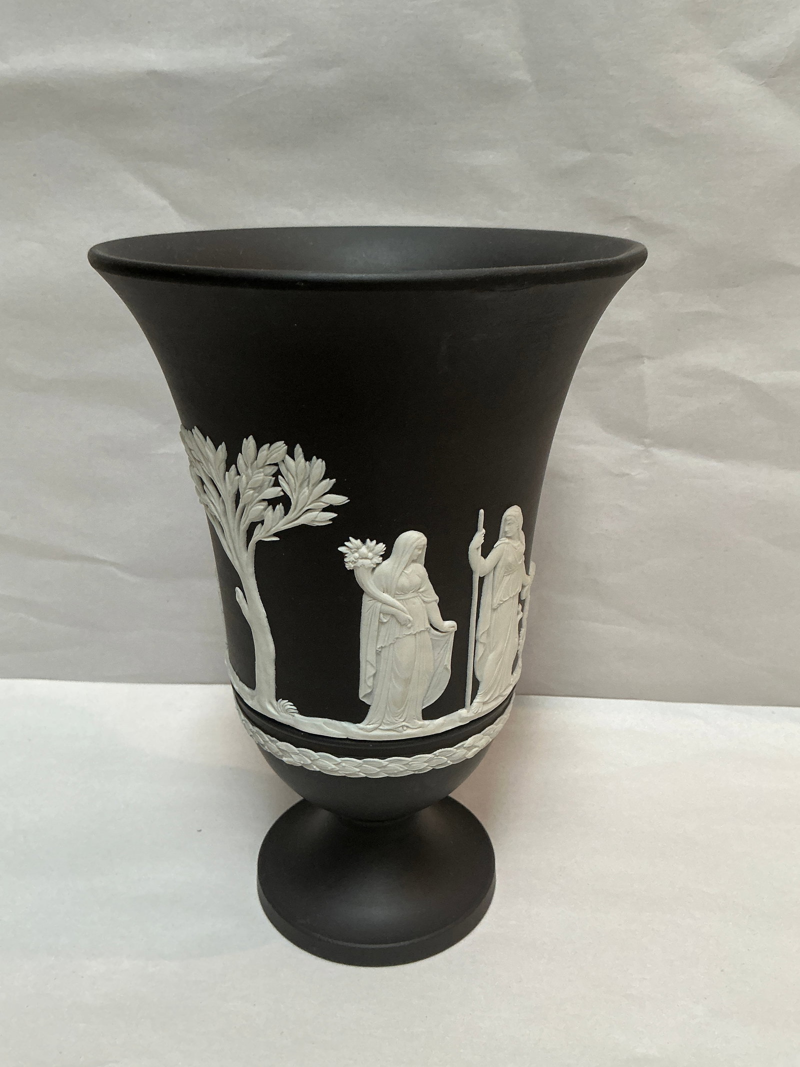 Black Wedgwood Jasperware Trumpet Vase with Neoclassical Motifs: This exquisite Black Wedgwood Jasperware trumpet vase stands at 7.25 inches tall with a 5-inch diameter, showcasing the brand's renowned craftsmanship. Embossed with intricate white neoclassical motif