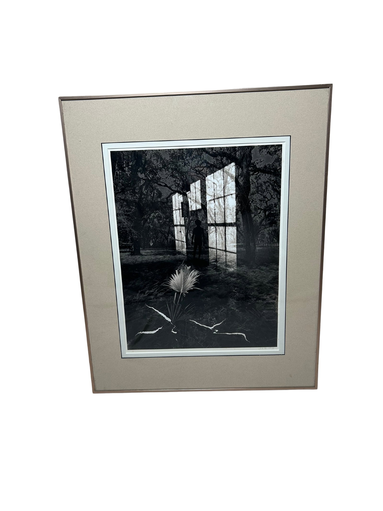 Monochrome Photograph with Reflective Shadows: This intriguing artwork is a black-and-white photograph encased in a delicate, thin frame, with dimensions of 10.5 inches in width and 13 inches in height, inclusive of the frame. The composition