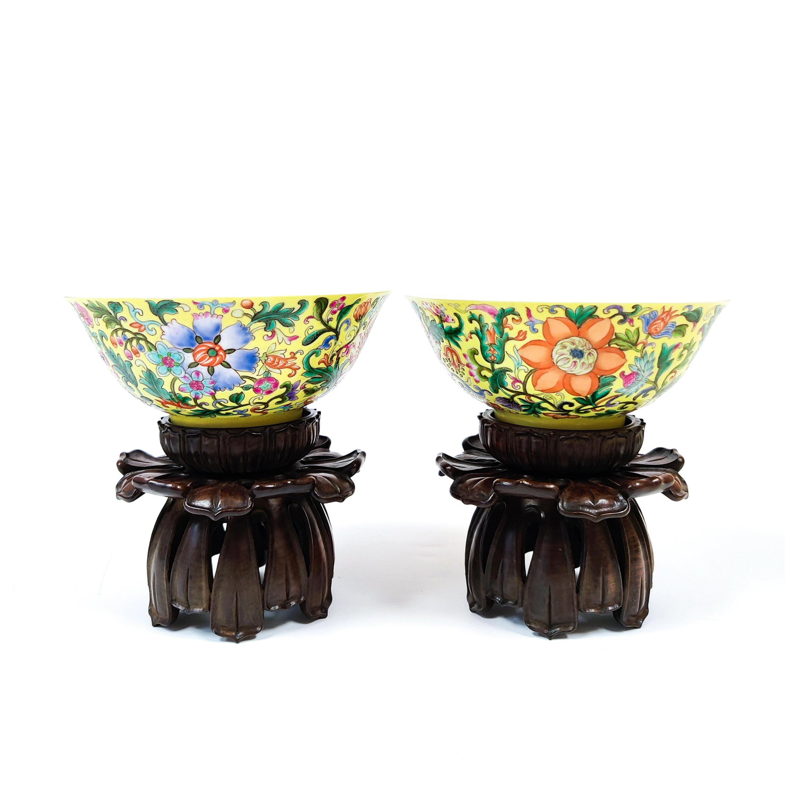 PAIR OF CHINESE FAMILLE ROSE YELLOW BOWLS ON STAND: Measurements: 2-5/8" H x 6-1/8" Dia. Stand: 3-5/8" H Pair of Chinese Qing Dynasty Famille rose Rococo Floral Blooms on Yellow Ground porcelain bowls on carved hardwood stands, with Qianlong Reign Mark