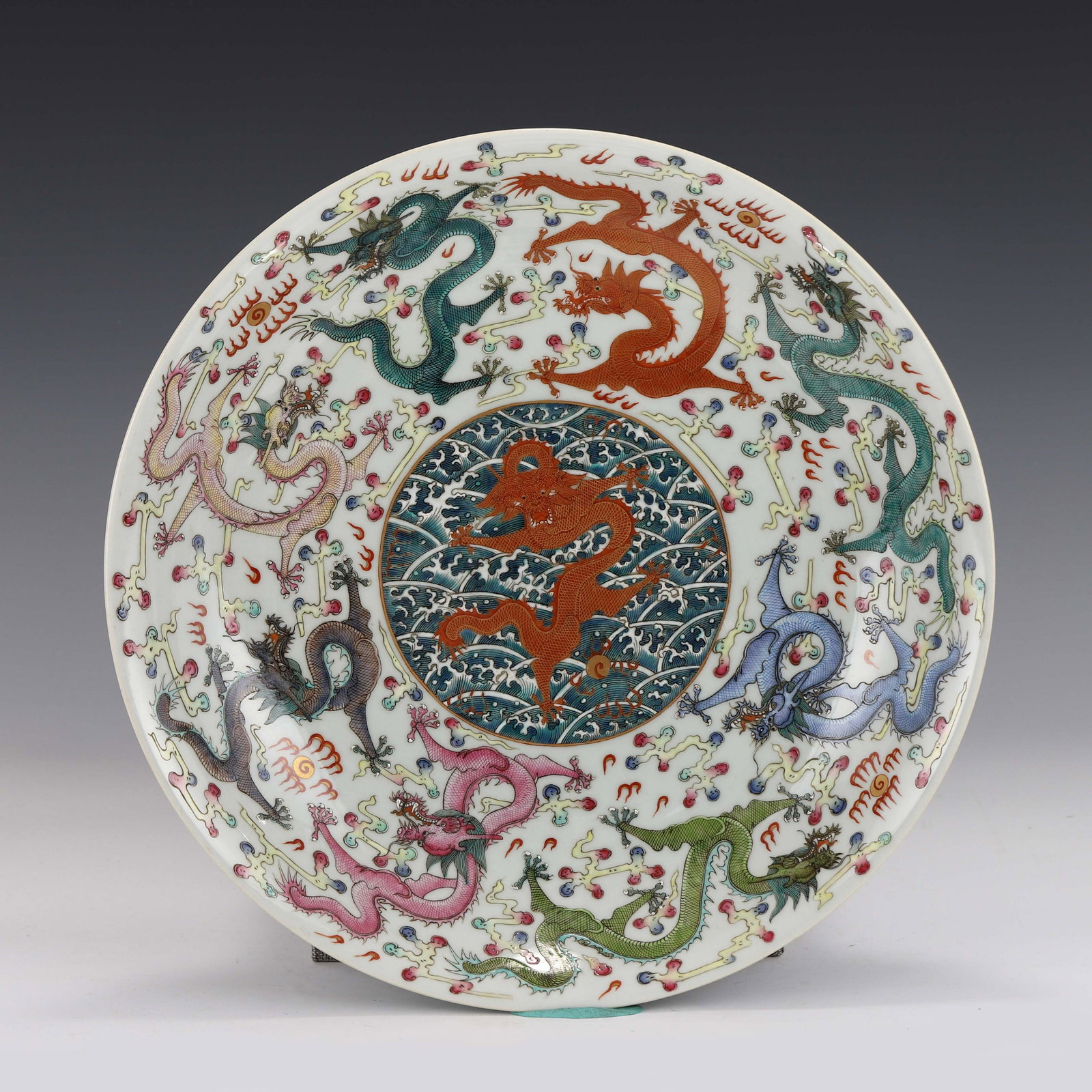 FAMILLE ROSE NINE DRAGONS PLATE: Chinese Qing Famille Rose Nine Dragons Motif Porcelain Plate. The Under-base bears a reign mark, a six under glazed blue script characters reign mark, enclosed within double fine blue rings, Made In T