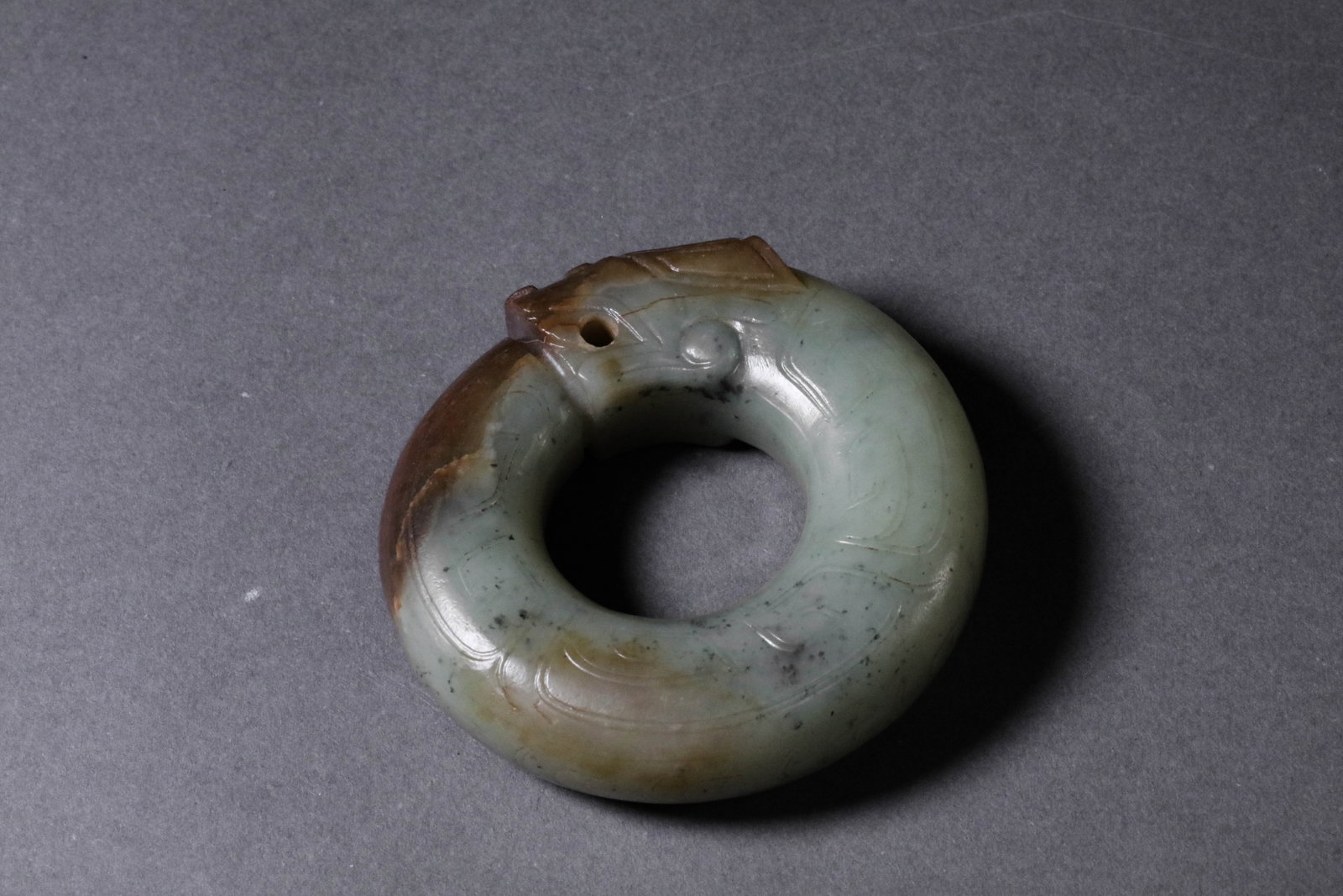 A Jade Dragon: A Jade Dragon Diam. : 7cm, Condition: Condition reports are rendered as specialist opinion by the staff of the Auction House and not as statements of fact. We do not guarantee the content of written o