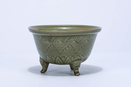 A CELADON CARVED 'WAVES' TRIPOD CENSER