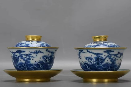 A PAIR OF BLUE AND WHITE WITH GILT-DECORATED 'AUSPICIOUS SEA' COVERED CUPS
