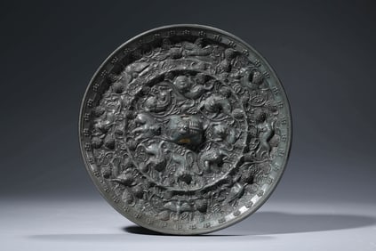 A BRONZE 'SEA CREATURES AND GRAPES' MIRROR