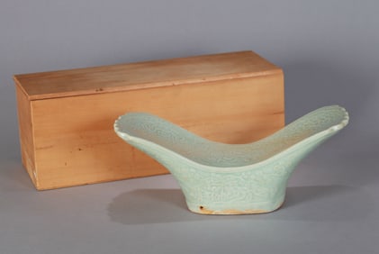 A CELADON-GLAZED STAMPED PORCELAIN PILLOW