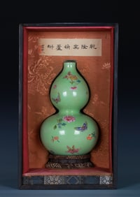 A GREEN-GROUND FAMILLE ROSE 'FLOWERS AND BUTTERFLIES' GOURD-SHAPED VASE