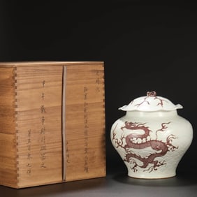 A UNDERGLAZED RED CARVED 'DRAGON IN WAVES' COVERED JAR