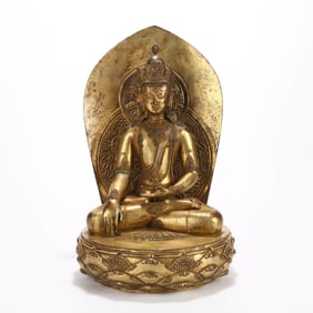 A GILT BRONZE 'CROWNED SHAKYAMUNI' FIGURE