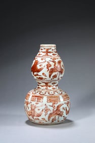 AN IRON-RED 'CRANES AND CLOUDS' GOURD SHAPED VASE