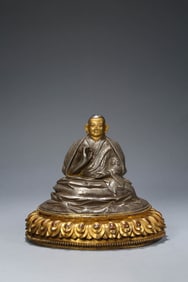 A TIBETAN GILT SILVER MASTER ON LOTUS THRONE