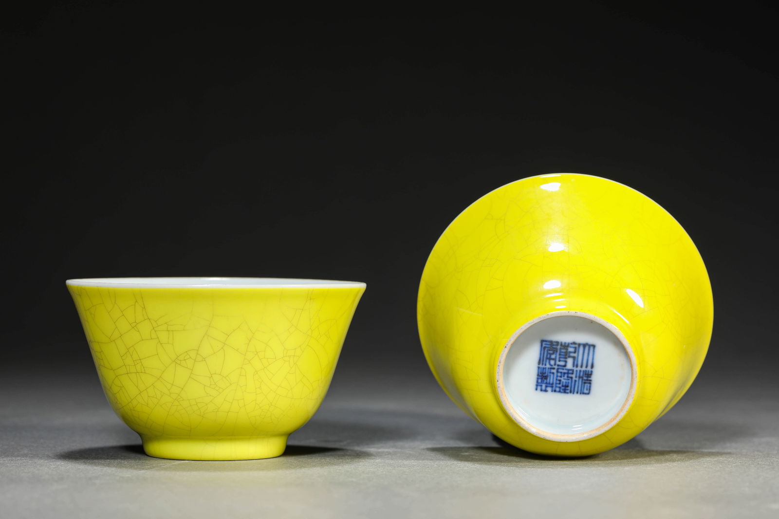 A PAIR OF LEMON-YELLOW GLAZED CUPS: A PAIR OF LEMON-YELLOW GLAZED CUPS Dimensions: Width: 8.3 cm (3.27 in) x Height: 4.8 cm (1.89 in). All measurements are approximate.