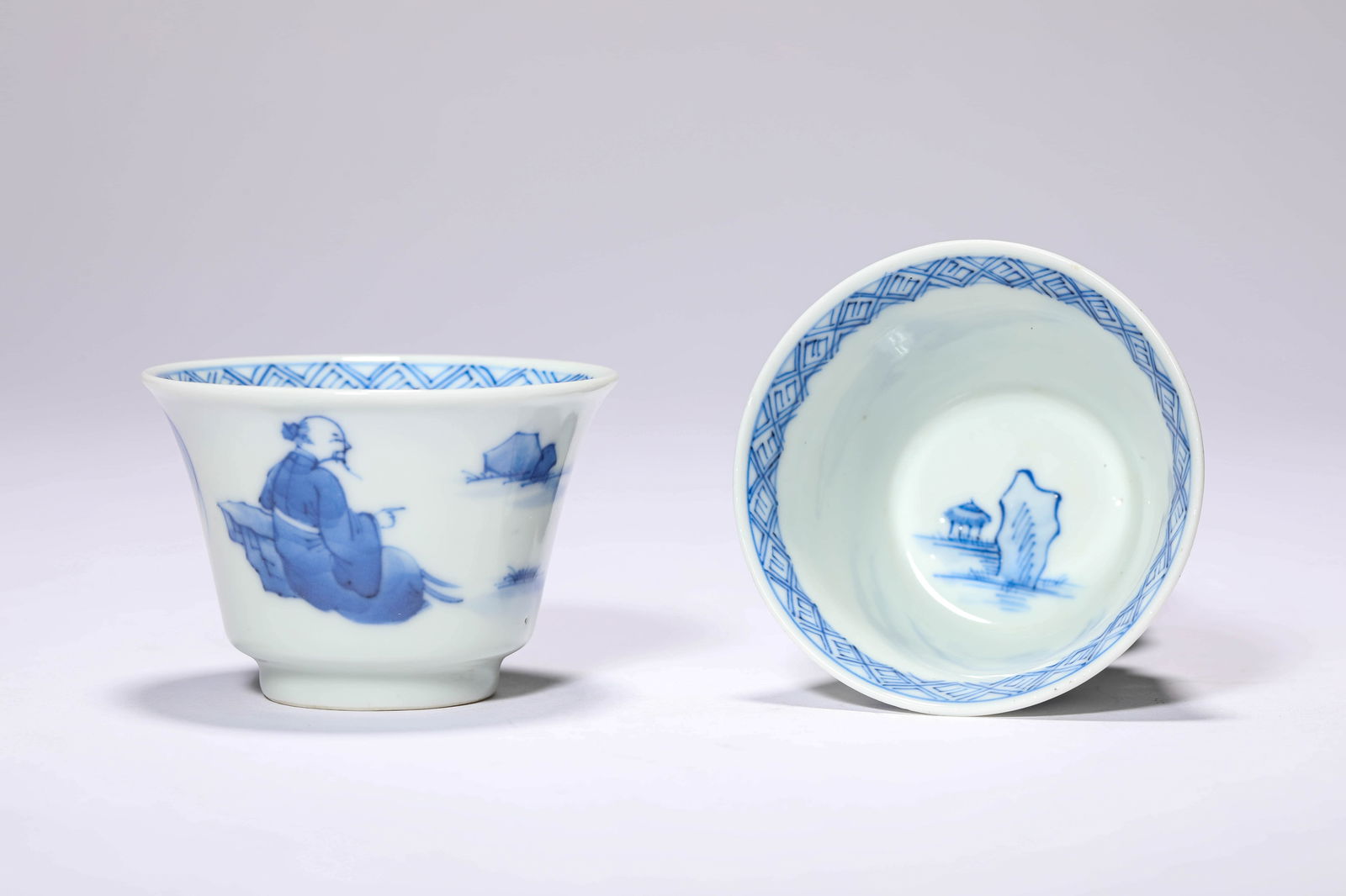 A PAIR OF BLUE AND WHITE 'FIGURE' CUPS: A PAIR OF BLUE AND WHITE 'FIGURE' CUPS Dimensions: Width: 6.7 cm (2.64 in) x Height: 4.7 cm (1.85 in). All measurements are approximate.