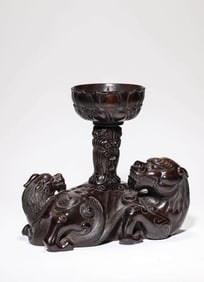 A ZITAN 'AUSPICIOUS BEAST' CANDLESTICK
