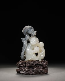 A WHITE JADE 'CHILD OFFERING LONGEVITY' CARVING WITH NATURAL COLORS