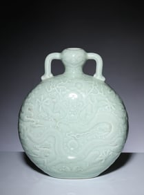 A CELADON GLAZED CARVED 'DRAGON' TWO-HANDLED VASE