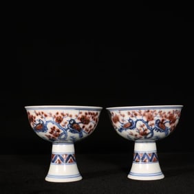 A PAIR OF BLUE AND WHITE AND UNDERGLAZE RED 'MAGPIES ON PLUM' STEM CUPS