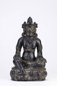 A TIBETAN BLACK SACRED STONE FIGURE OF YELLOW JAMBHALA